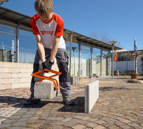 Ein Bauarbeiter arbeitet mit Werkzeugen von Ambros-Technik.